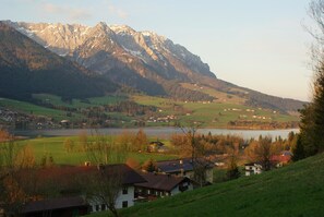 A mountainous landscape with a lake, houses, and a small village.