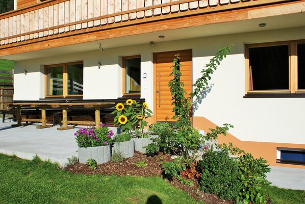 Un bâtiment doté d’un balcon en bois, d’une porte en bois et d’une fenêtre.