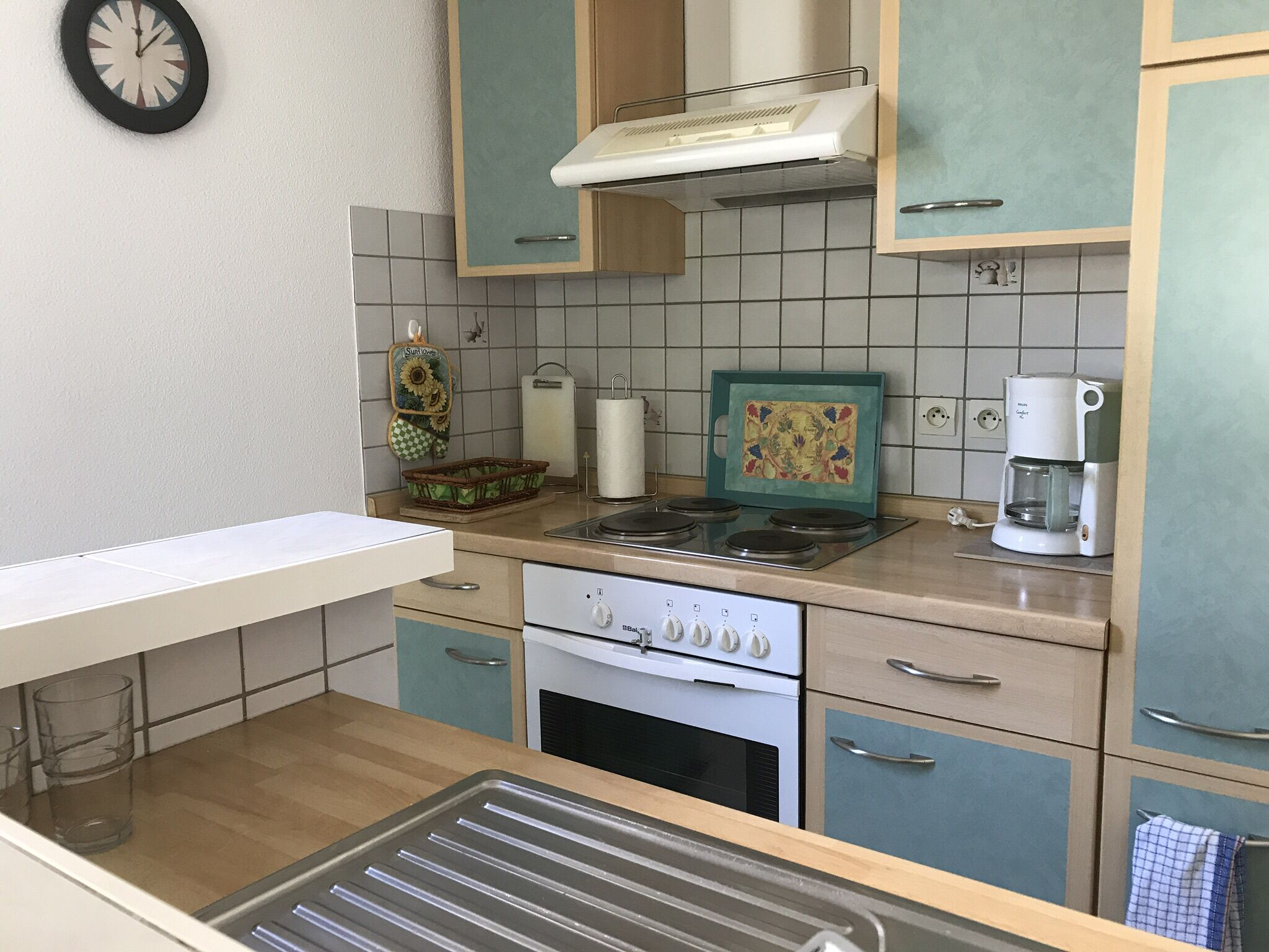 A kitchen with a stove, oven, and coffee maker.