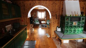 A cozy kitchen with wooden walls, a green cabinet, a bench, and a tiled floor. - cozy house in a sunny place with a fantastic mountain panorama (Bad Mitterndorf)