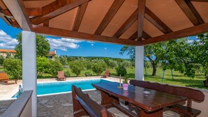 A covered outdoor area with a pool, wooden benches, and a table. - Quiet and secluded, minutes to beach, private pool in a wonderful garden (Trget)