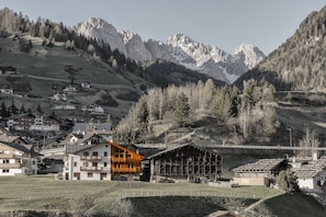 Un village de montagne avec des bâtiments de style chalet traditionnel, un chalet en bois et une vue sur des sommets enneigés.