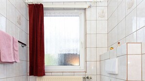 Ein Badezimmer mit Toilette, Waschbecken und Fenster.
