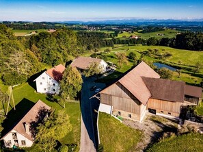 Un paysage rural avec une grange, une maison blanche et une route.