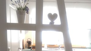 A bedroom with a bed, a window, and a view of a kitchen. - Apartment water lily Remseck (Remseck am Neckar)