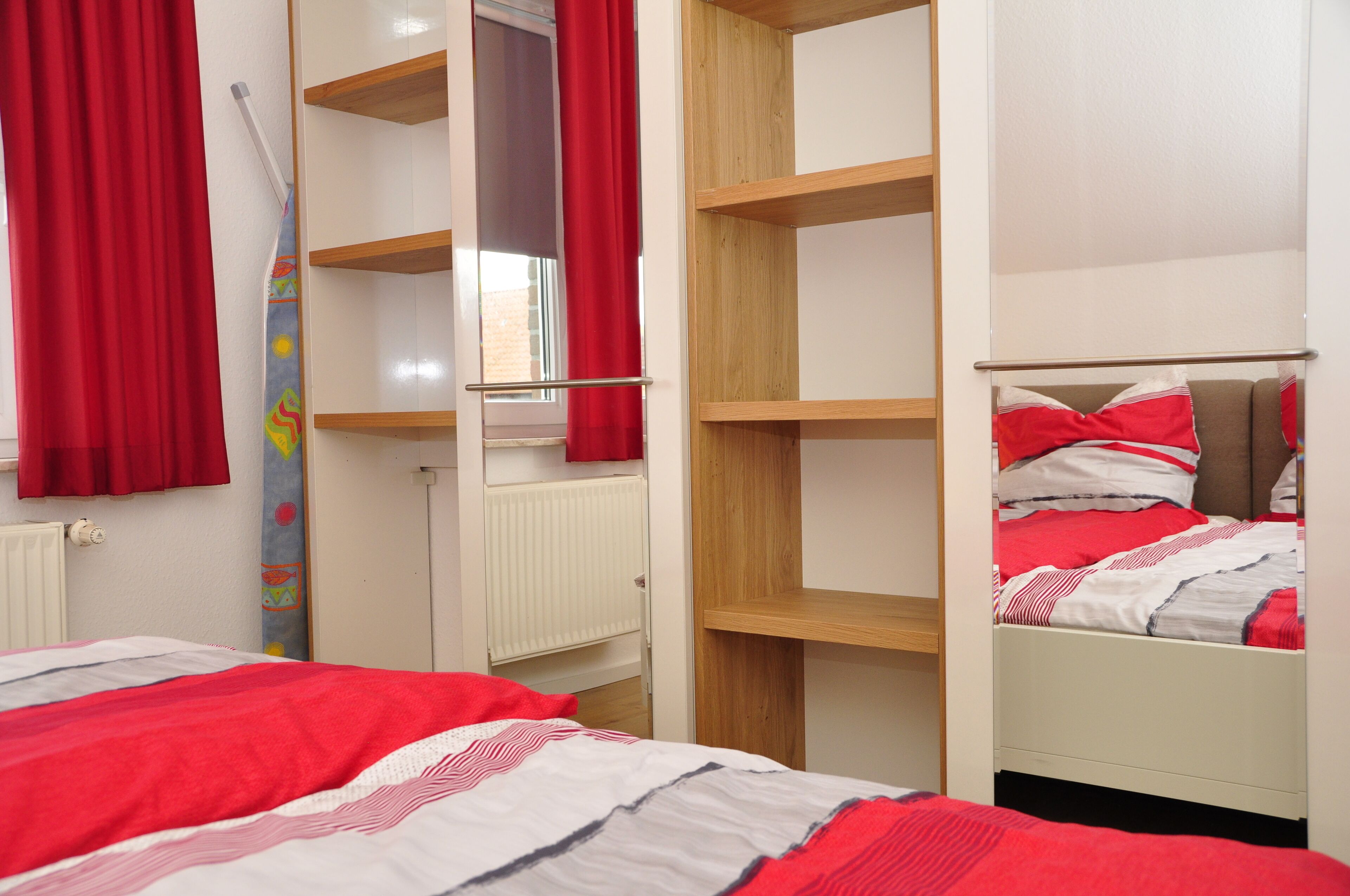 A bedroom with a bed, a wardrobe, and a radiator.