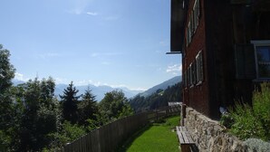 A wooden building with a stone wall and a wooden fence. - self-catering holiday house (about 130m²), ideal for 2-3 families (Blons)