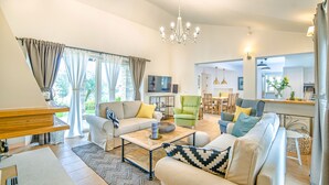 A spacious living room with a sofa set, a coffee table, and a television.