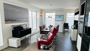 A modern kitchen with a dining area, large windows, and a painting on the wall. - WoogeDiva - the highest apartment on Wangerooge (Wangerooge)