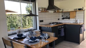 A modern kitchen with a central island, black cabinetry, and a window with a view of greenery. - Nature house near Amsterdam Peace and beautiful view of private rental (Breukelen)