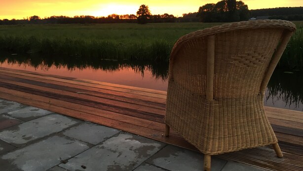 A wicker chair by a calm water body with a sunset in the background. - Nature house near Amsterdam Peace and beautiful view of private rental (Breukelen)