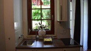 A kitchen with a window, a sink, a vase with flowers, and a note on the counter. - Hoffmann's apartment in the residence Bocksbergblick (Goslar)