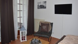A room with a bed, a chair with a heart-shaped pillow, a small table with candles, a lantern, and a picture on the wall. - Hoffmann's apartment in the residence Bocksbergblick (Goslar)