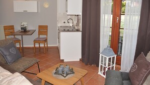 A compact living space with a kitchenette, a dining area, and a seating area with a coffee table. - Hoffmann's apartment in the residence Bocksbergblick (Goslar)