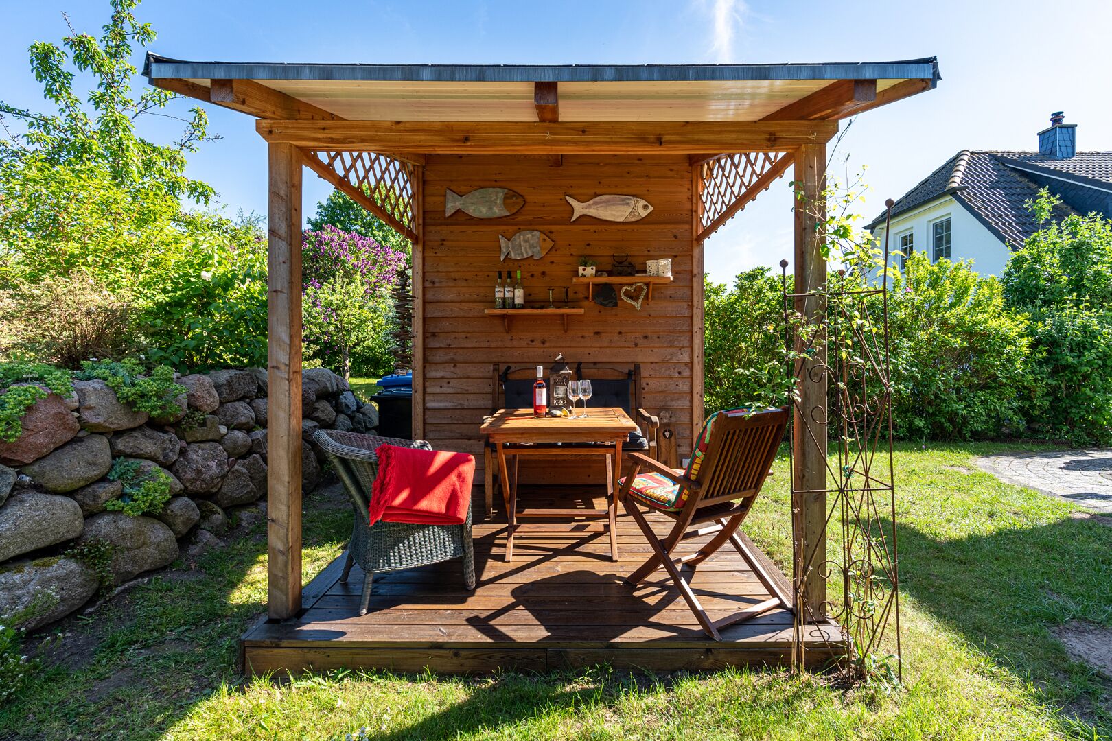 Un espacio de descanso al aire libre con mesa, sillas y un pérgola.