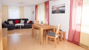 A modern living room with a sofa, a dining table, and a chair. - Quiet, TV, WiFi, terrace, lake, parking (Füssen)