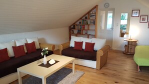 Een gezellige woonkamer met twee banken, een salontafel en een boekenkast.