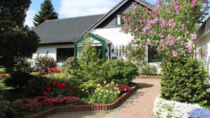 Een huis met een tuin, een kas en een pad.