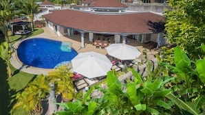 Ein Resort mit Schwimmbad, Außenbereich und üppiger Bepflanzung.