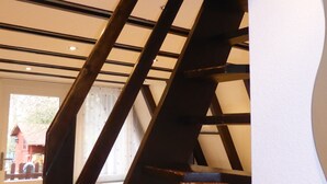 Un interior moderno con una escalera de madera que conduce a un comedor.