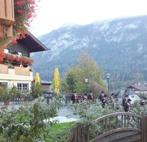 A mountain view with a wooden bridge and a building with outdoor seating. - Holiday home - Müllers Holiday Salzburgerland (Niederland)