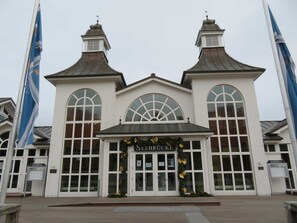 A building with a central entrance, large arched windows, and two symmetrical towers.