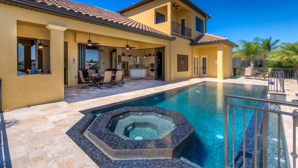 A two-story house with a swimming pool and a hot tub. - Luxury villa in a prime location with an oversized pool and whirlpool (Cape Coral)