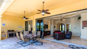 A spacious living area with a dining table, chairs, a sofa, and a ceiling fan. - Luxury villa in a prime location with an oversized pool and whirlpool (Cape Coral)