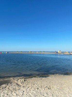Een strand met een zandrijk strand en een helderblauwe lucht.