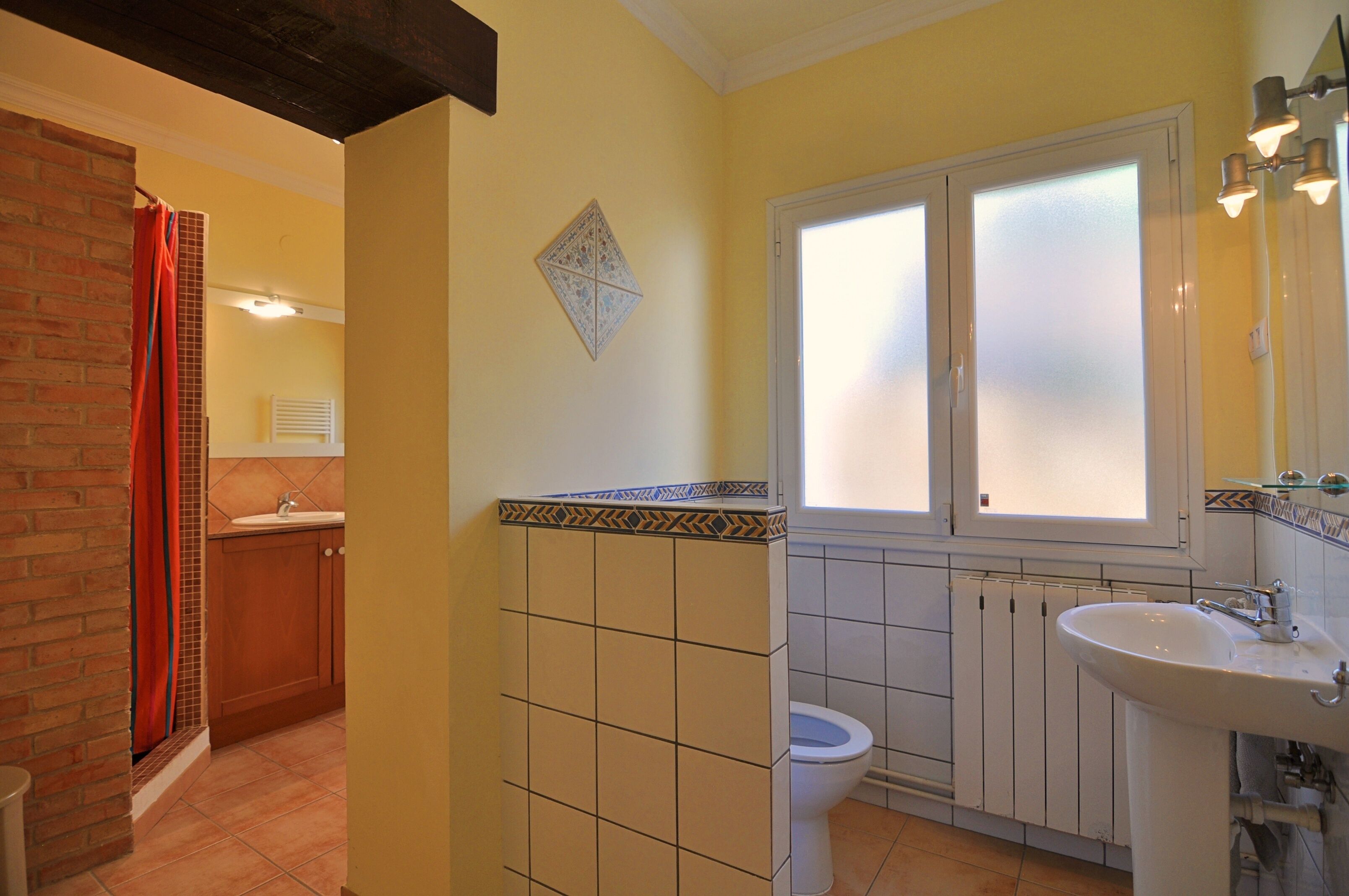 A bathroom with a white sink, a toilet, and a shower area.
