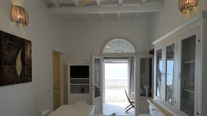 A modern kitchen with a dining area, white cabinetry, and a view to the beach. - Casa Viale Italia - homely house with direct access to the sandy beach (Follonica)