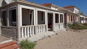 A beachfront property with a covered patio, steps leading to the entrance, and a bicycle parked outside. - Casa Viale Italia - homely house with direct access to the sandy beach (Follonica)