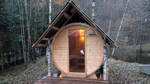 A wooden cabin with a circular shape, a pitched roof, and a door with a glass panel. - Family-friendly holiday home in the most beautiful hiking area!  (Arnbruck)