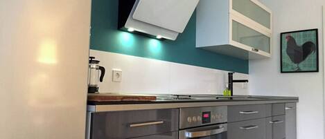 A modern kitchen with a built-in oven, a microwave, and a coffee maker.