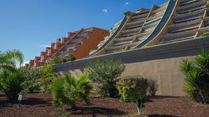Un edificio moderno con varios balcones y un diseño inclinado.