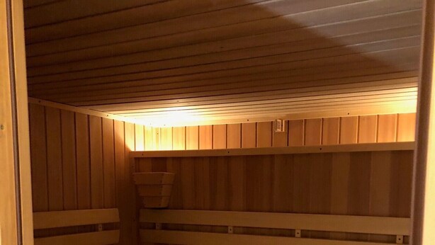 Een sauna met houten banken en een schuin dak.