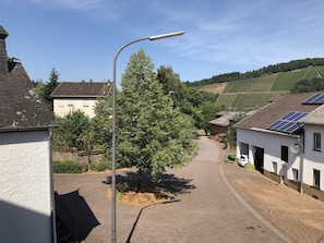 Une rue bordée de maisons, un lampadaire et un arbre.