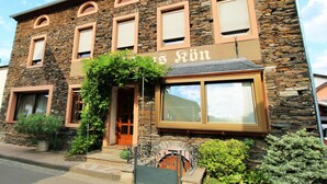 Un bâtiment en pierre sur lequel on peut lire l’inscription : « Hôtel Ron ».