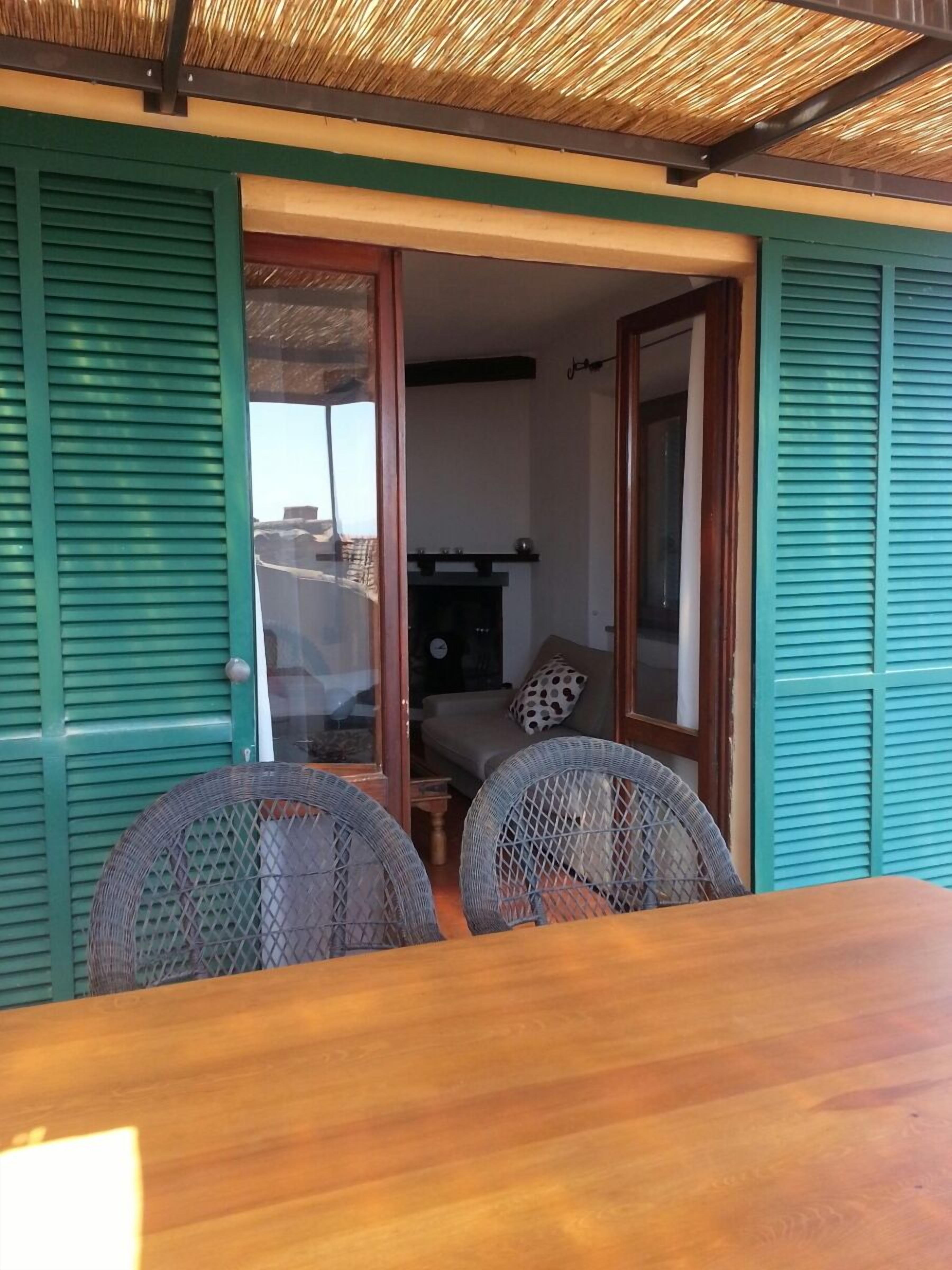 An open doorway leading to a living area with a sofa and a fireplace. There is a table with chairs in the foreground.