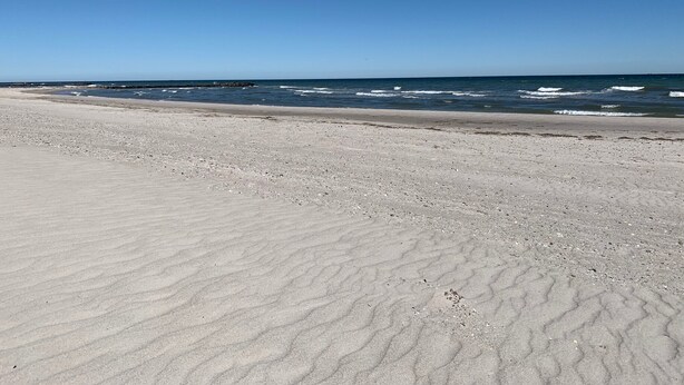 A beach with a wide sandy shore and the ocean in the background. - Only 250m to the beach - for 4 pers., 70sqm, large balcony. South-facing garden/terrace, conservatory (Schönberger Strand)
