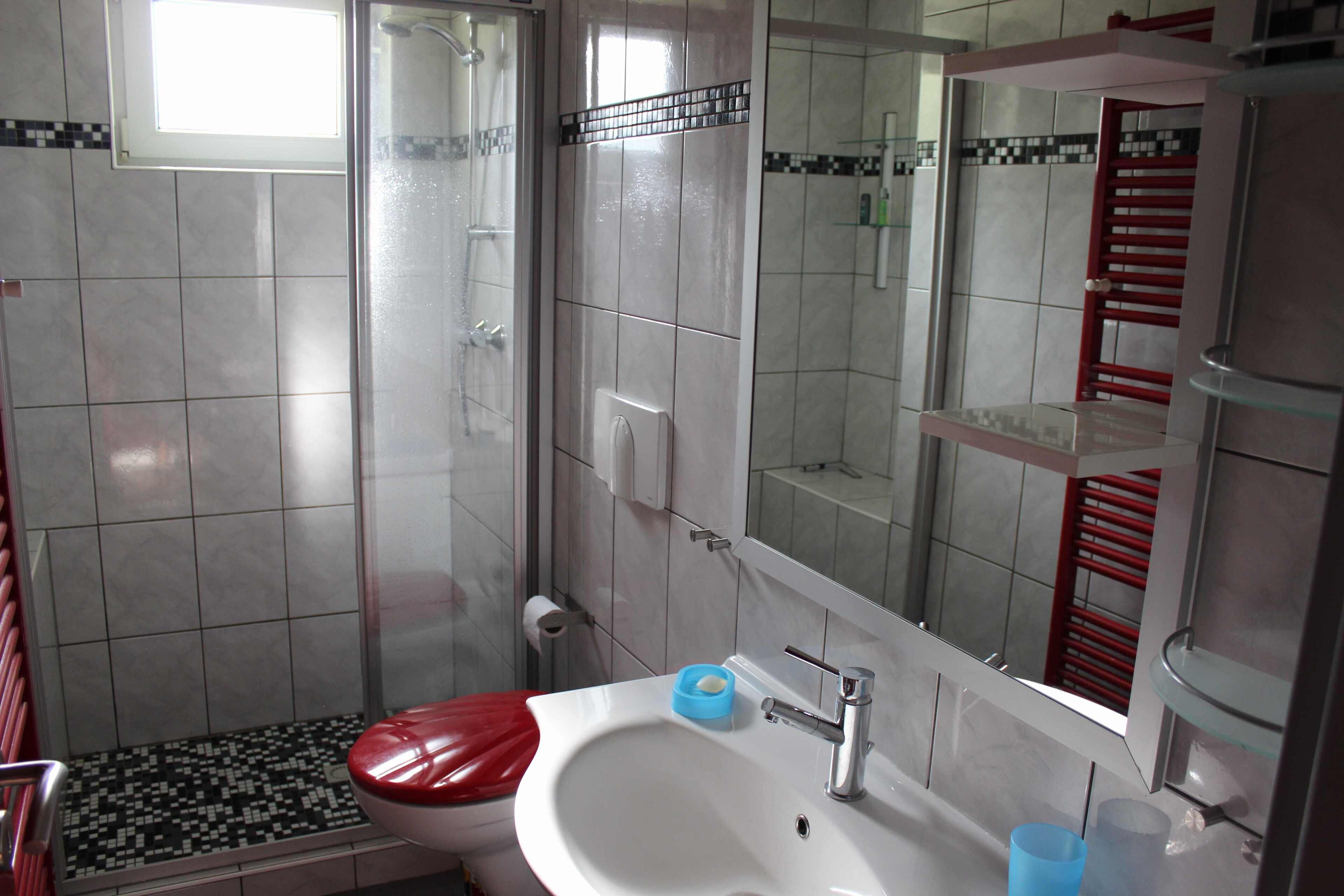 A bathroom with a toilet, sink, and shower.