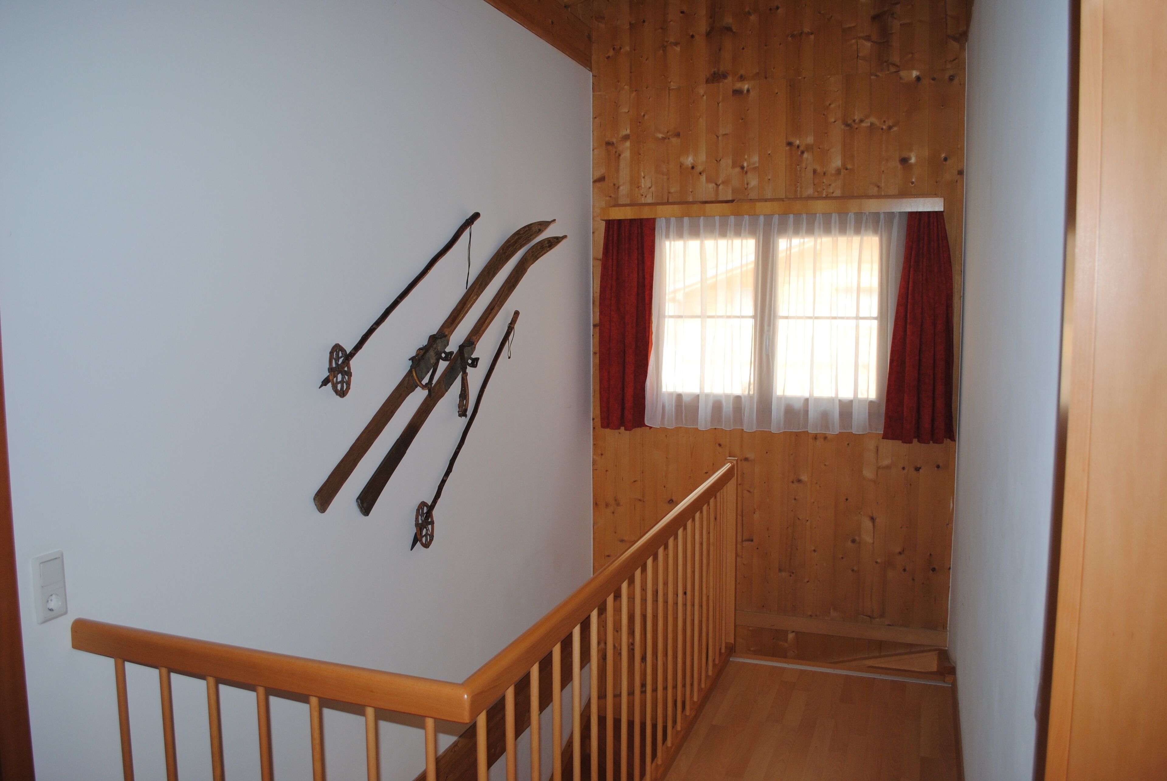 A staircase with wooden railings and a wall-mounted ski rack.