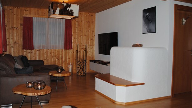 Un salon chaleureux avec un plafond en bois, un canapé, une table basse, un téléviseur et une cheminée.