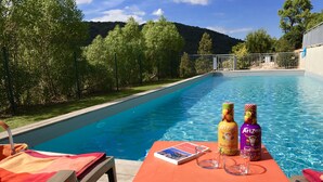 Una zona de piscina amb una taula, dues ampolles de Arizona fruit punch i un fullet.