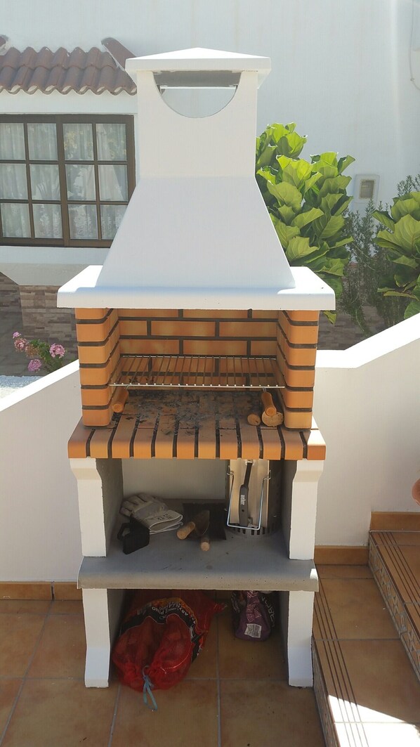 A brick-built outdoor oven with a white chimney, a grill, and a bag of charcoal. - A stone's throw from the Atlantic Ocean - 50 meters to the sea (Los Silos)