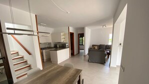 A modern kitchen with white cabinets, a wooden island, and a dining area with a wooden table. - A stone's throw from the Atlantic Ocean - 50 meters to the sea (Los Silos)