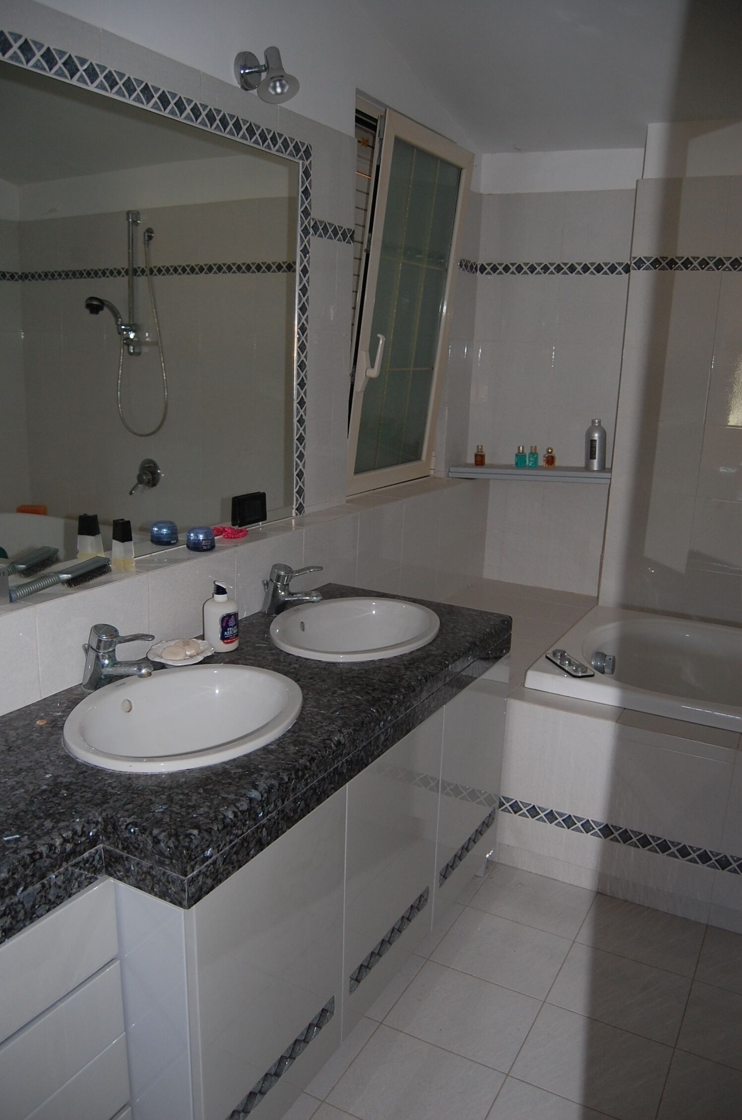 Ein Badezimmer mit zwei Waschbecken, einem großen Spiegel und einer Dusche.