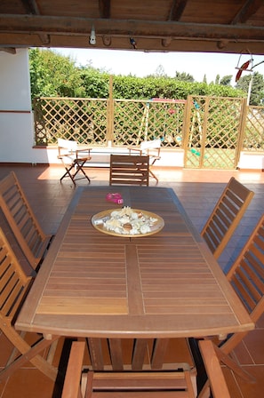 Enjoy dining al fresco in this charming outdoor patio area with a beautifully set table and comfortable seating.
