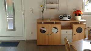 Une cuisine avec un meuble en bois, une horloge et une fenêtre.