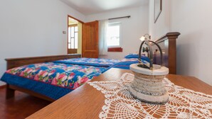 A bedroom with a wooden bed, a decorative table lamp, and a lace doily on the table. - Vila Pavincica with swimming pool, soccer pitch and award-winning honey tasting (LABIN)
